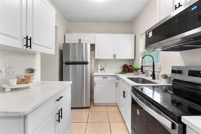 5115 W Livingston St, Orlando, FL 32811 - kitchen featuring stainless steel appliances, white cabinets, light countertops, and light tile patterned floors