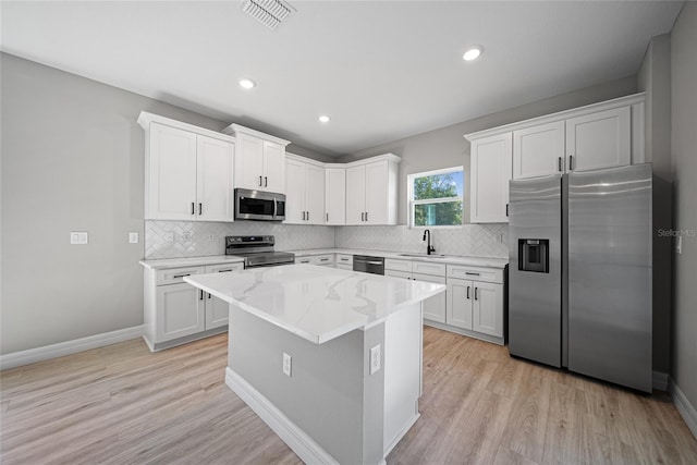 3944 SW 130th Loop, Ocala, FL 34473 - kitchen with stainless steel appliances, tasteful backsplash, light wood-type flooring, a sink, and light stone counters