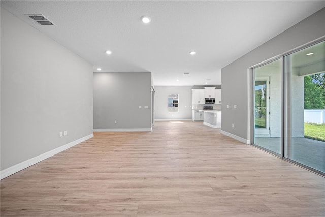3944 SW 130th Loop, Ocala, FL 34473 - unfurnished living room featuring light wood-style flooring, baseboards, and recessed lighting