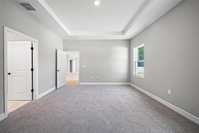 3944 SW 130th Loop, Ocala, FL 34473 - unfurnished bedroom featuring a tray ceiling, light colored carpet, and baseboards