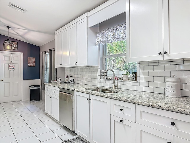 3104 Lime Tree Dr, Edgewater, FL 32141 - kitchen with stainless steel dishwasher, a sink, vaulted ceiling, white cabinetry, and light stone counters