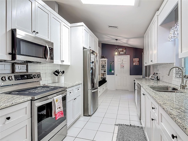 3104 Lime Tree Dr, Edgewater, FL 32141 - kitchen with stainless steel appliances, a sink, light tile patterned flooring, white cabinetry, and decorative backsplash