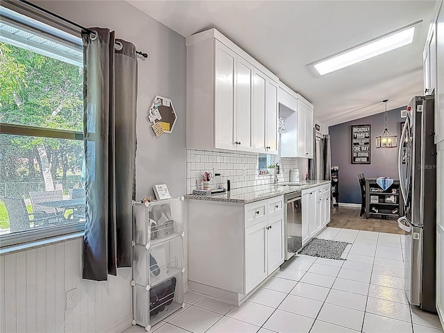 3104 Lime Tree Dr, Edgewater, FL 32141 - kitchen featuring appliances with stainless steel finishes, vaulted ceiling, a sink, white cabinets, and backsplash