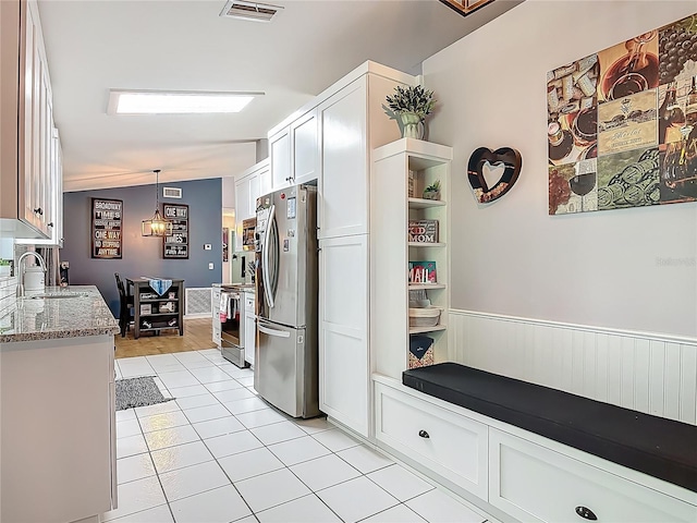 3104 Lime Tree Dr, Edgewater, FL 32141 - kitchen with appliances with stainless steel finishes, light tile patterned flooring, white cabinets, light stone counters, and a sink