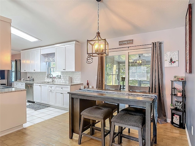 3104 Lime Tree Dr, Edgewater, FL 32141 - kitchen featuring backsplash, a chandelier, white cabinetry, a sink, and stainless steel dishwasher