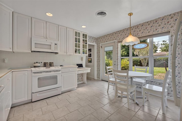 2040 Mohawk Trl, Maitland, FL 32751 - kitchen featuring white appliances, light countertops, white cabinets, plenty of natural light, and wallpapered walls