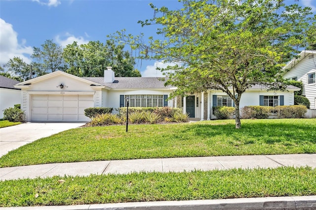 2040 Mohawk Trl, Maitland, FL 32751 - view of front of house featuring an attached garage, concrete driveway, a front yard, and a chimney