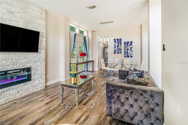 7838 Rollingridge Ct, Orlando, FL 32835 - living area with wood finished floors, a stone fireplace, and baseboards