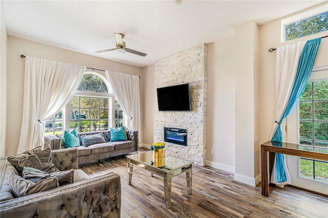 7838 Rollingridge Ct, Orlando, FL 32835 - living room featuring a ceiling fan, wood finished floors, a fireplace, and baseboards