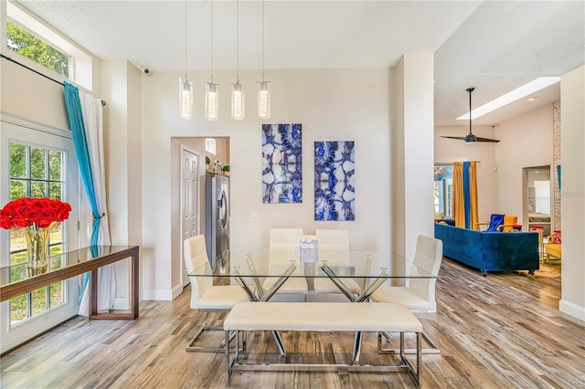 7838 Rollingridge Ct, Orlando, FL 32835 - dining area featuring wood finished floors, baseboards, and a towering ceiling