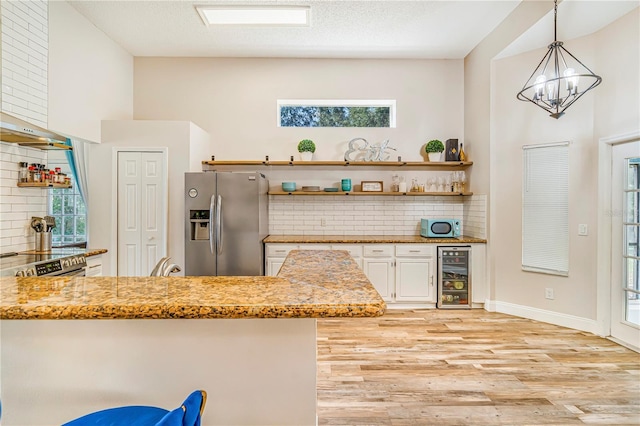 7838 Rollingridge Ct, Orlando, FL 32835 - kitchen featuring stainless steel appliances, beverage cooler, decorative backsplash, light wood-style floors, and light stone countertops