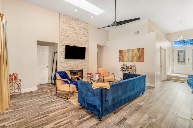 7838 Rollingridge Ct, Orlando, FL 32835 - living room with light wood-style flooring, baseboards, a towering ceiling, and a fireplace