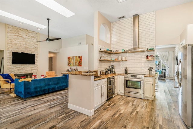 7838 Rollingridge Ct, Orlando, FL 32835 - kitchen with stainless steel appliances, high vaulted ceiling, a peninsula, open floor plan, and a skylight