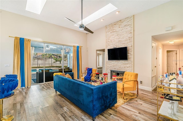 7838 Rollingridge Ct, Orlando, FL 32835 - living room featuring a skylight, high vaulted ceiling, wood finished floors, a fireplace, and a ceiling fan