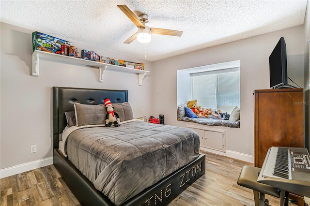7838 Rollingridge Ct, Orlando, FL 32835 - bedroom featuring wood finished floors, a textured ceiling, baseboards, and a ceiling fan
