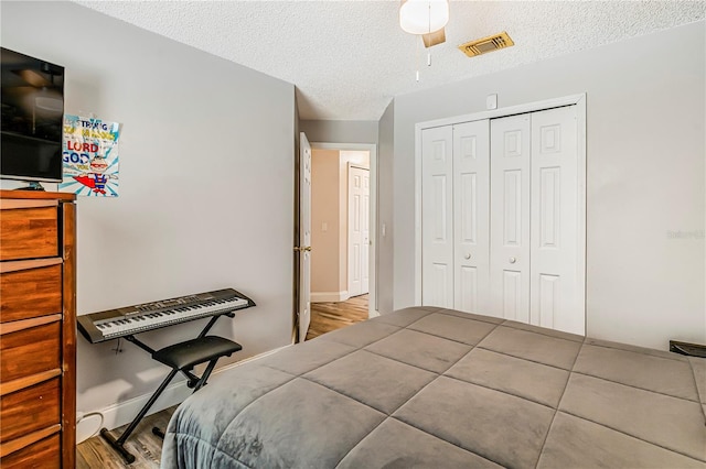 7838 Rollingridge Ct, Orlando, FL 32835 - bedroom with a textured ceiling, a closet, wood finished floors, baseboards, and ceiling fan