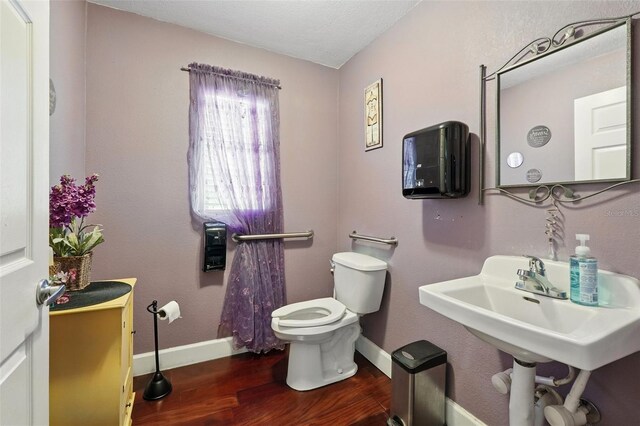 205 S Highland Ave, Apopka, FL 32703 - bathroom with wood finished floors, toilet, and baseboards