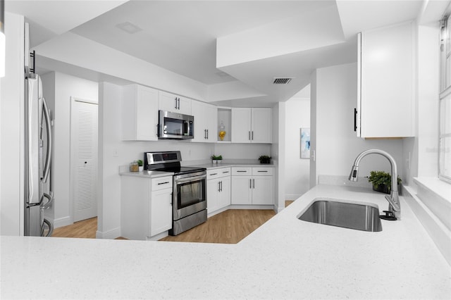 2903 Clear Way, Orlando, FL 32805 - kitchen featuring appliances with stainless steel finishes, light wood-style floors, and white cabinets