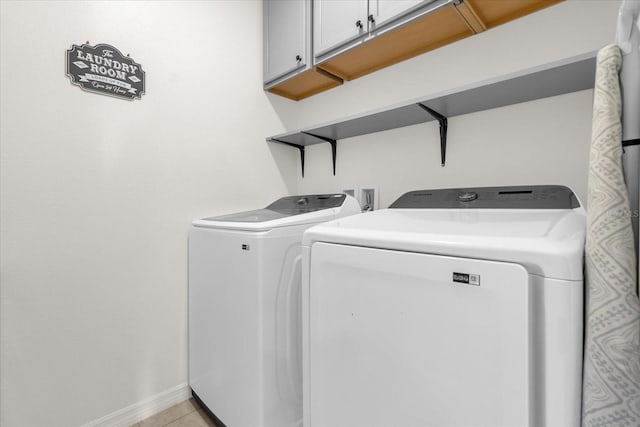 123 Zinnia Ln W, Poinciana, FL 34759 - washroom featuring washer and clothes dryer, cabinet space, baseboards, and light tile patterned floors