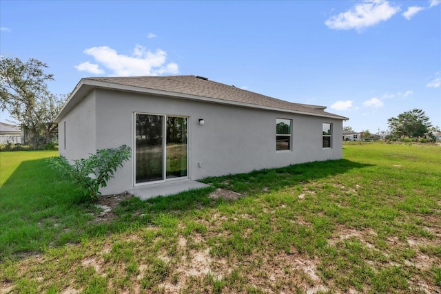 123 Zinnia Ln W, Poinciana, FL 34759 - rear view of property with stucco siding and a yard