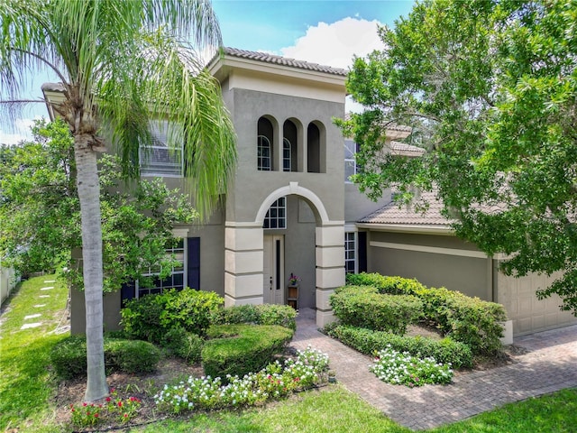 3213 Kentshire Blvd, Ocoee, FL 34761 - mediterranean / spanish-style house with stucco siding, a garage, and a tile roof