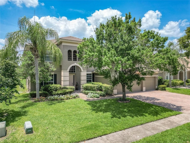 3213 Kentshire Blvd, Ocoee, FL 34761 - mediterranean / spanish-style house with stucco siding, decorative driveway, a front yard, a tile roof, and an attached garage