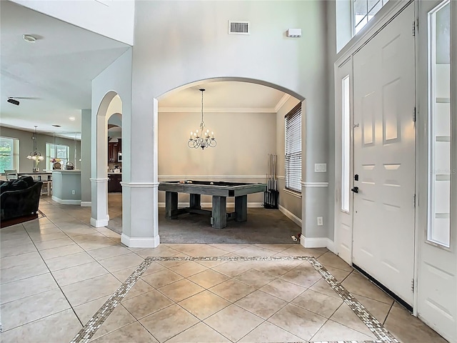 3213 Kentshire Blvd, Ocoee, FL 34761 - foyer with baseboards, crown molding, arched walkways, a chandelier, and a high ceiling
