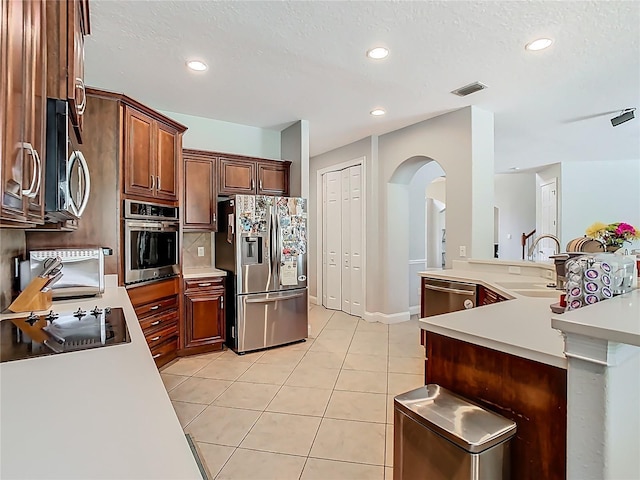 3213 Kentshire Blvd, Ocoee, FL 34761 - kitchen with stainless steel appliances, a sink, arched walkways, light countertops, and light tile patterned floors