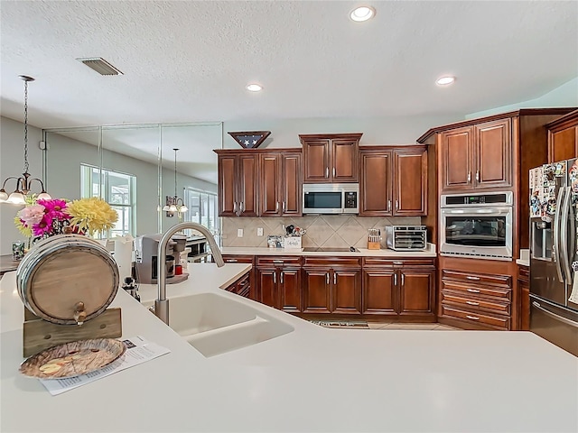 3213 Kentshire Blvd, Ocoee, FL 34761 - kitchen featuring stainless steel appliances, a sink, tasteful backsplash, light countertops, and decorative light fixtures