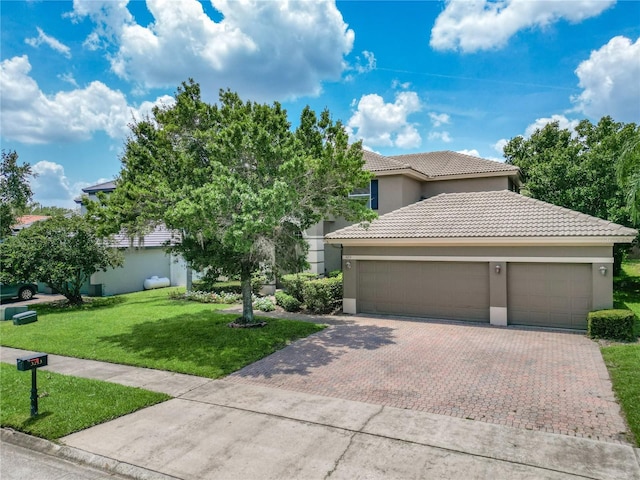 3213 Kentshire Blvd, Ocoee, FL 34761 - view of front of home with a tiled roof, decorative driveway, stucco siding, a garage, and a front lawn