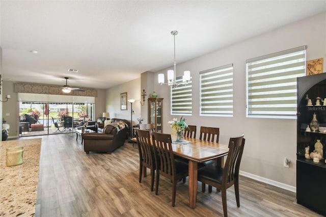 2941 Marlberry Ln, Clermont, FL 34714 - dining space with wood finished floors, a chandelier, and a ceiling fan