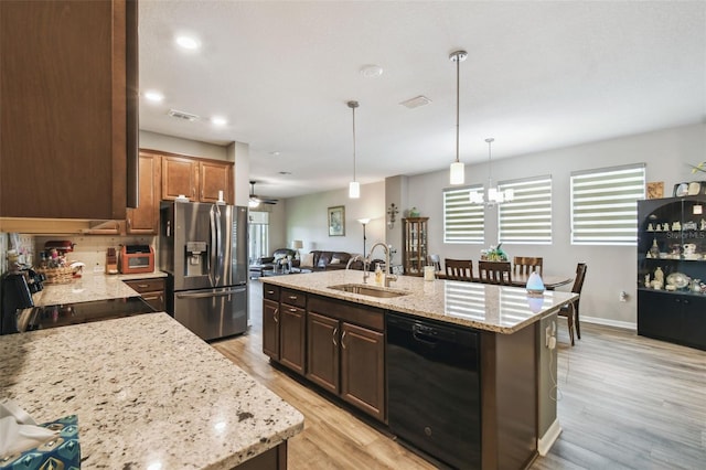 2941 Marlberry Ln, Clermont, FL 34714 - kitchen featuring dishwasher, stainless steel refrigerator with ice dispenser, light wood finished floors, an island with sink, and a chandelier