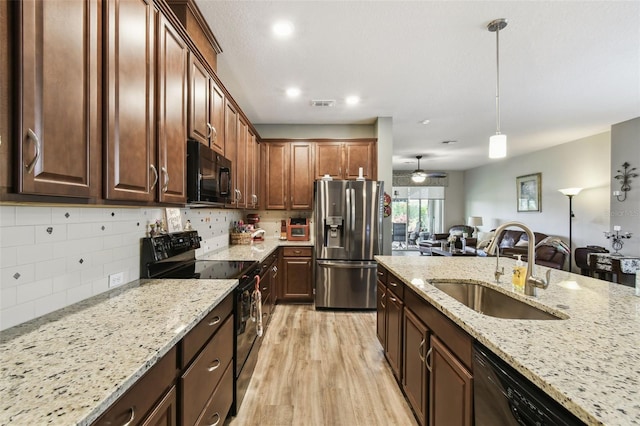 2941 Marlberry Ln, Clermont, FL 34714 - kitchen with black appliances, light wood-style flooring, tasteful backsplash, light stone counters, and recessed lighting