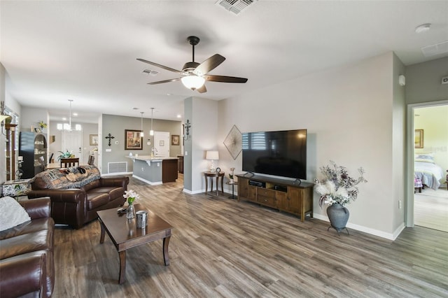 2941 Marlberry Ln, Clermont, FL 34714 - living area with wood finished floors, a ceiling fan, and a chandelier