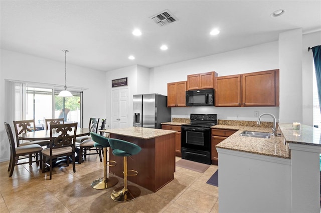 30245 Cheval St, Mount Dora, FL 32757 - kitchen with black appliances, a sink, brown cabinets, a breakfast bar, and pendant lighting