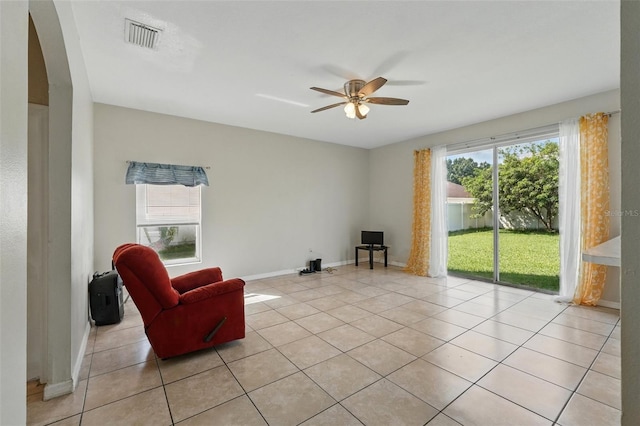 4208 Lugano Ct, Kissimmee, FL 34746 - sitting room with arched walkways, ceiling fan, light tile patterned flooring, and baseboards