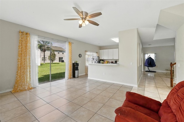 4208 Lugano Ct, Kissimmee, FL 34746 - living area featuring light tile patterned floors, healthy amount of natural light, a ceiling fan, and baseboards