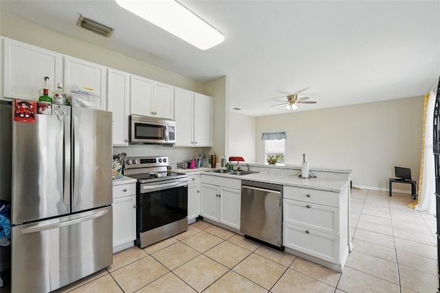 4208 Lugano Ct, Kissimmee, FL 34746 - kitchen with stainless steel appliances, a peninsula, light tile patterned floors, and white cabinetry