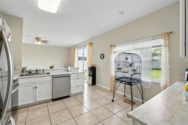 4208 Lugano Ct, Kissimmee, FL 34746 - kitchen with appliances with stainless steel finishes, ceiling fan, white cabinetry, a sink, and light tile patterned floors