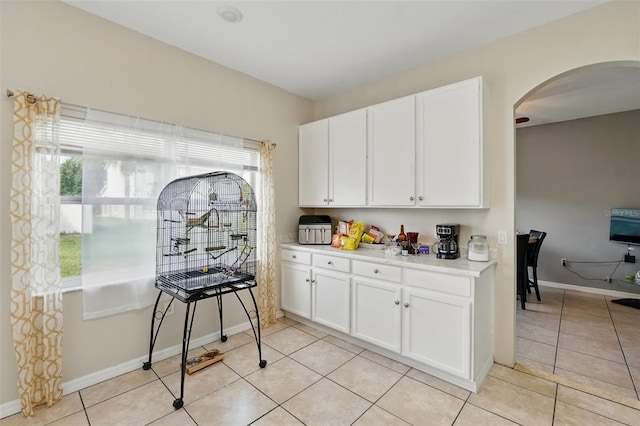 4208 Lugano Ct, Kissimmee, FL 34746 - kitchen with arched walkways, healthy amount of natural light, light countertops, and white cabinets