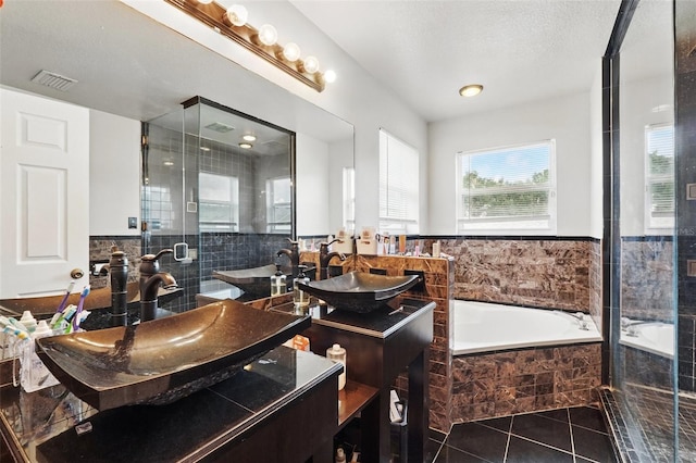 4208 Lugano Ct, Kissimmee, FL 34746 - full bathroom featuring tile patterned floors, a bath, a shower stall, double vanity, and tile walls