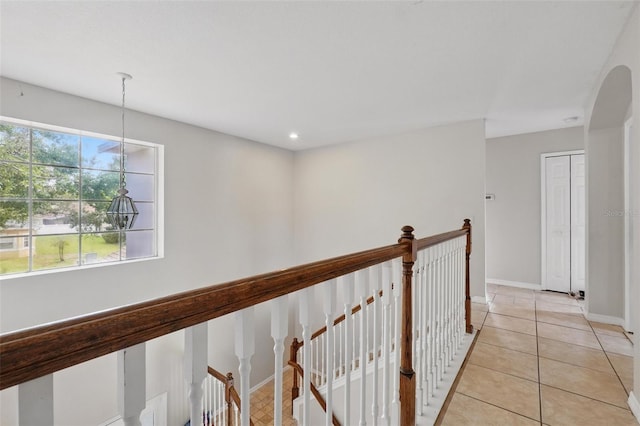 4208 Lugano Ct, Kissimmee, FL 34746 - corridor featuring an upstairs landing, light tile patterned flooring, and baseboards