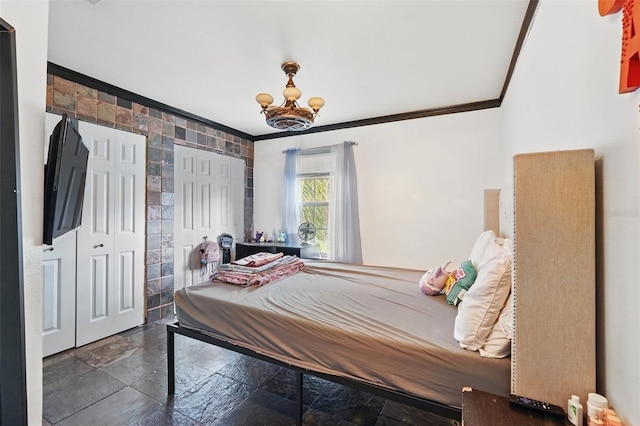 4208 Lugano Ct, Kissimmee, FL 34746 - bedroom with ornamental molding, stone tile floors, a chandelier, multiple closets, and tile walls