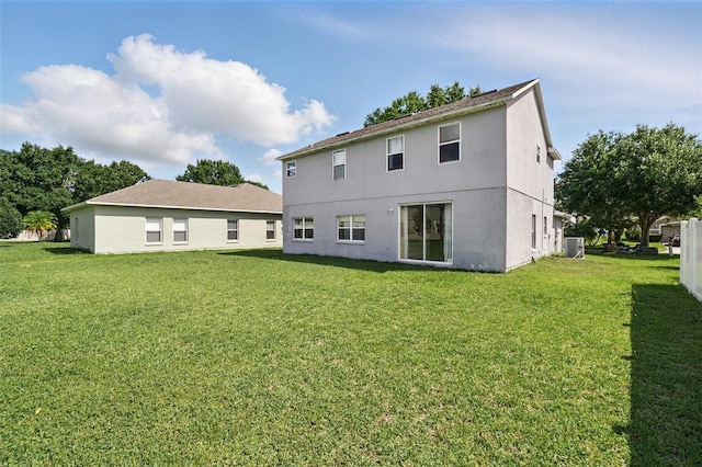 4208 Lugano Ct, Kissimmee, FL 34746 - rear view of property featuring a lawn, stucco siding, and central AC unit