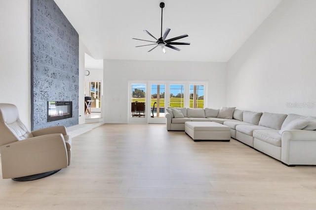 5913 Masters Blvd, Orlando, FL 32819 - living area with a ceiling fan, high vaulted ceiling, a multi sided fireplace, and light wood-style flooring