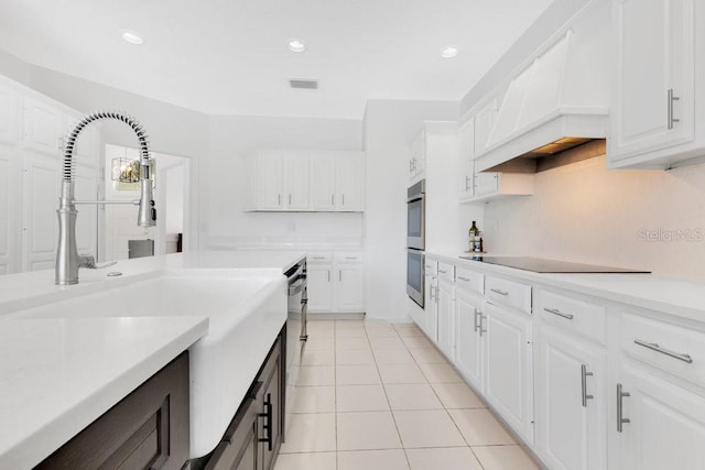5913 Masters Blvd, Orlando, FL 32819 - kitchen featuring a sink, stainless steel double oven, light countertops, light tile patterned flooring, and white cabinetry