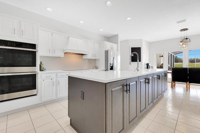 5913 Masters Blvd, Orlando, FL 32819 - kitchen featuring appliances with stainless steel finishes, custom range hood, white cabinets, light countertops, and light tile patterned flooring