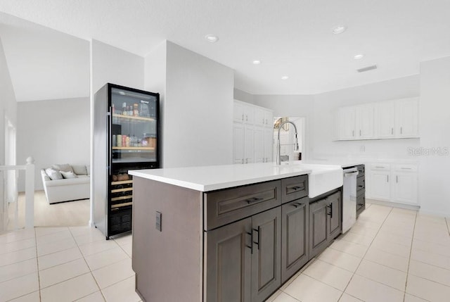 5913 Masters Blvd, Orlando, FL 32819 - kitchen with beverage cooler, white cabinetry, light tile patterned flooring, stainless steel dishwasher, and recessed lighting