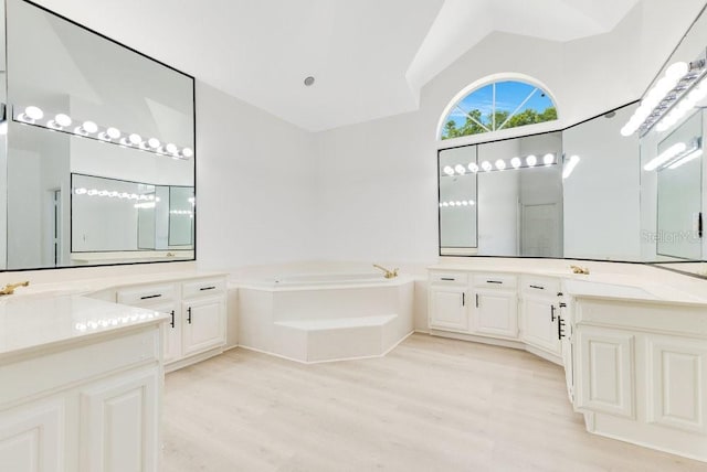 5913 Masters Blvd, Orlando, FL 32819 - bathroom with wood finished floors, a garden tub, vaulted ceiling, and two vanities