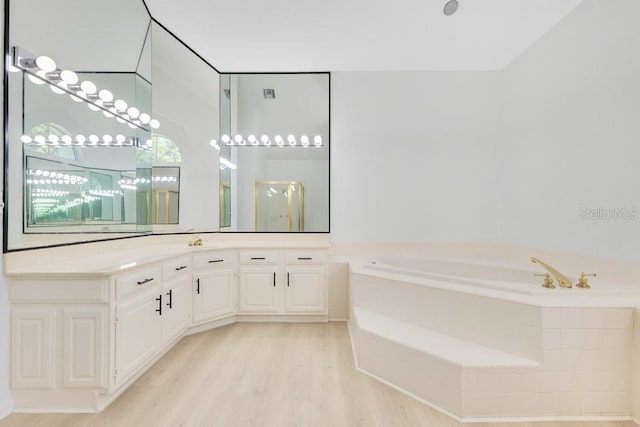 5913 Masters Blvd, Orlando, FL 32819 - bathroom with a garden tub, wood finished floors, a shower stall, and vanity